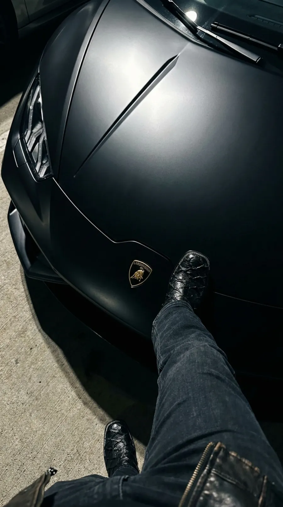 Exotic leather boots worn beside a Lamborghini